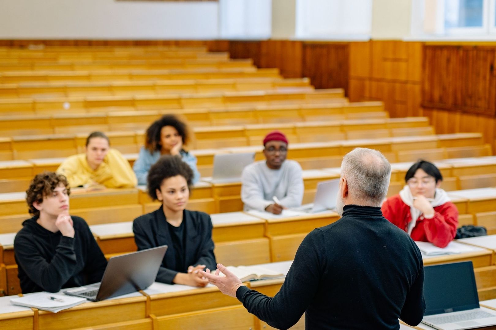 Teacher addressing a diverse group of students in a lecture hall